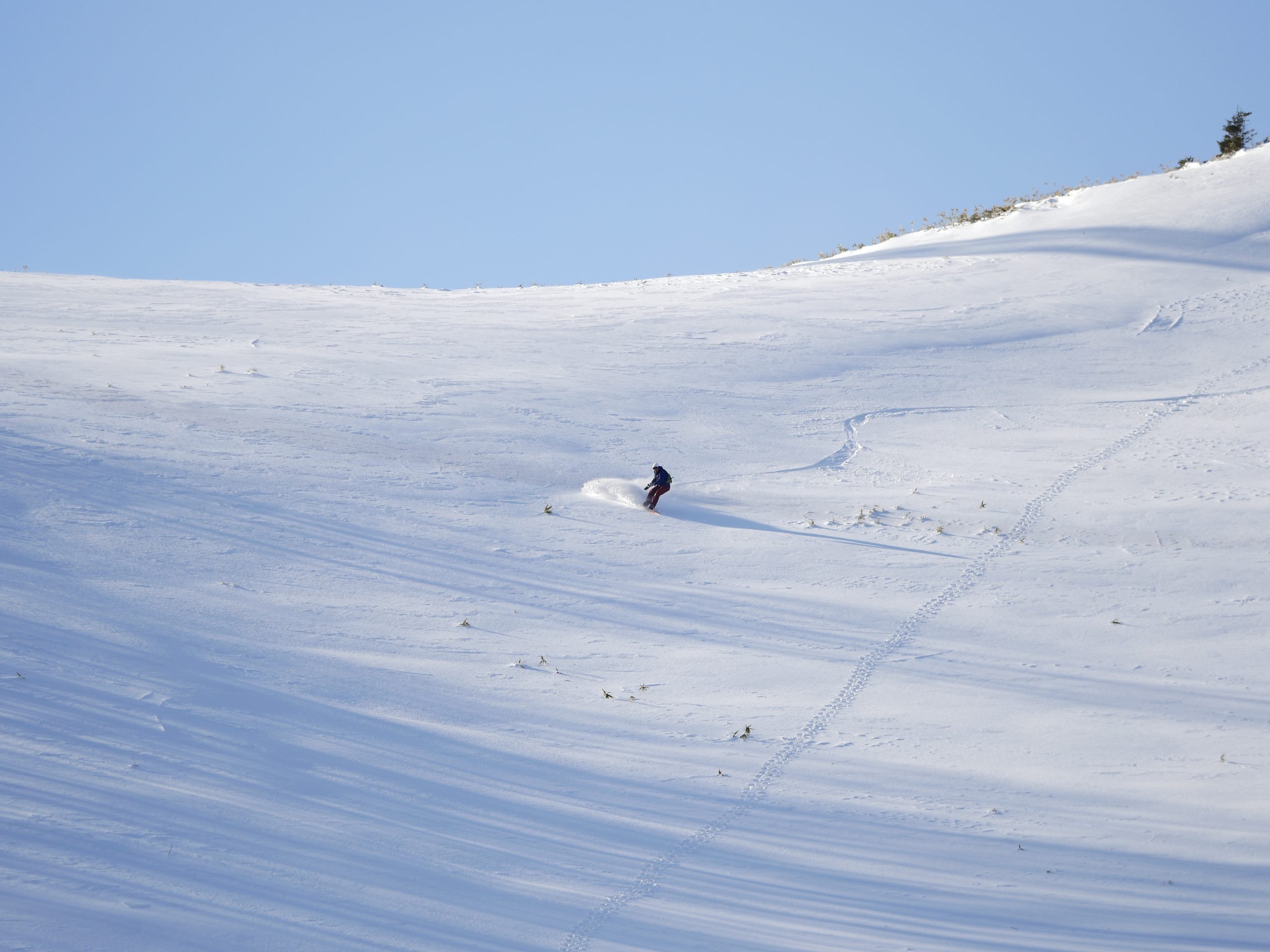 Un snowboard descend une piste enneigée